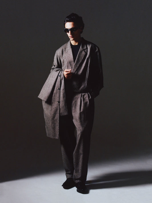 Man in shadows wearing the Lavelle Trousers and Rico Jacket styled as a grey flecked wool cropped suit.