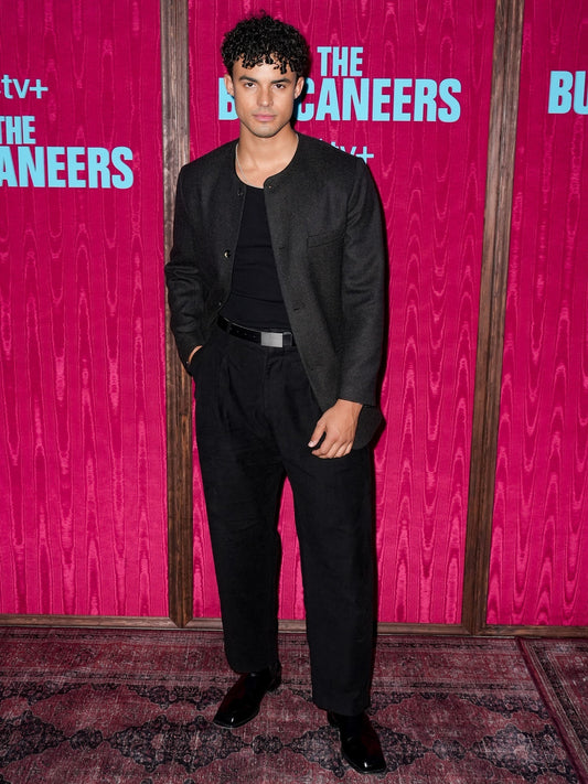 Matthew Broome wearing Heron’s Ghyll brown and black tweed collarless jacket with moleskin inverted-pleat trousers at The Buccaneers Season 2 photo call