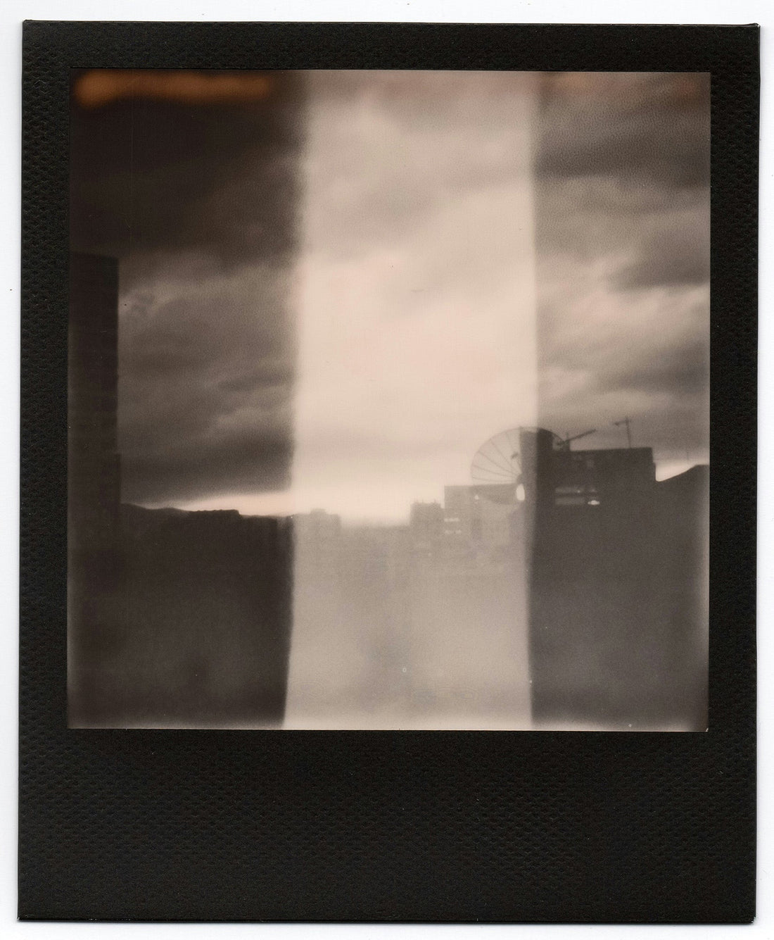 Black and white polaroid of a city skyline.
