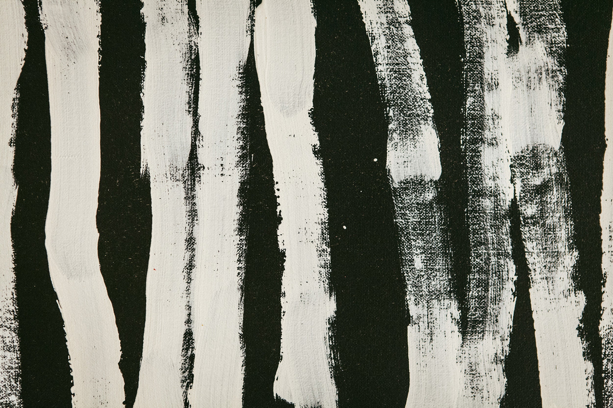 An abstract painting of white textured paint smears in crooked, vertical lines on a black board.